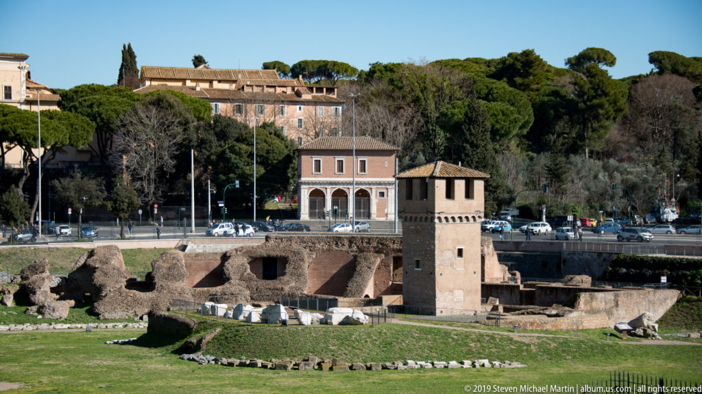Square medieval Torre della Moletta rising among excavated brick remains at the Circus Maximus.