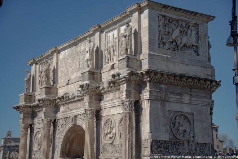 Oblique view of the Arch of Constantine showing the central arch, columns, reliefs, roundels, and inscribed attic.