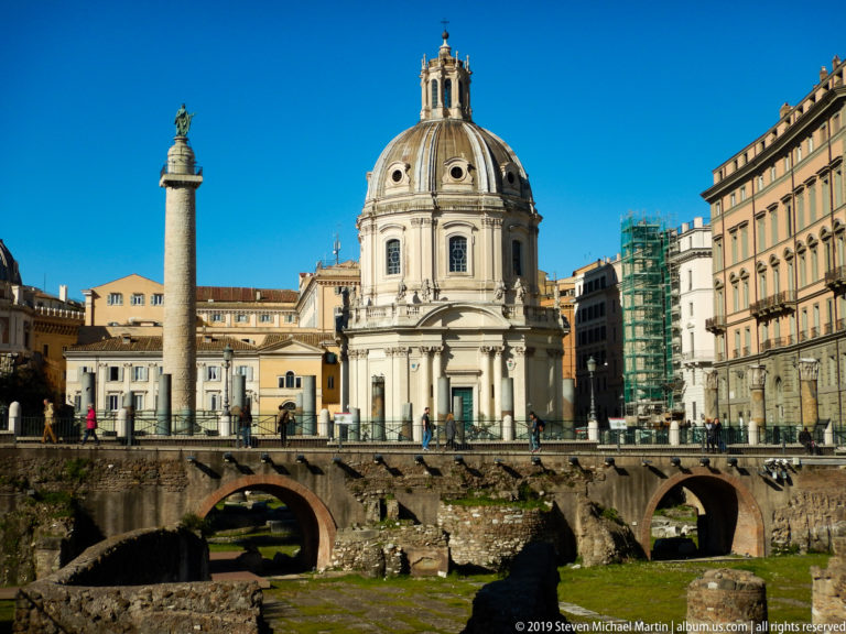 Excavated Roman arches and masonry below Trajan's Column and the domed Santa Maria di Loreto.