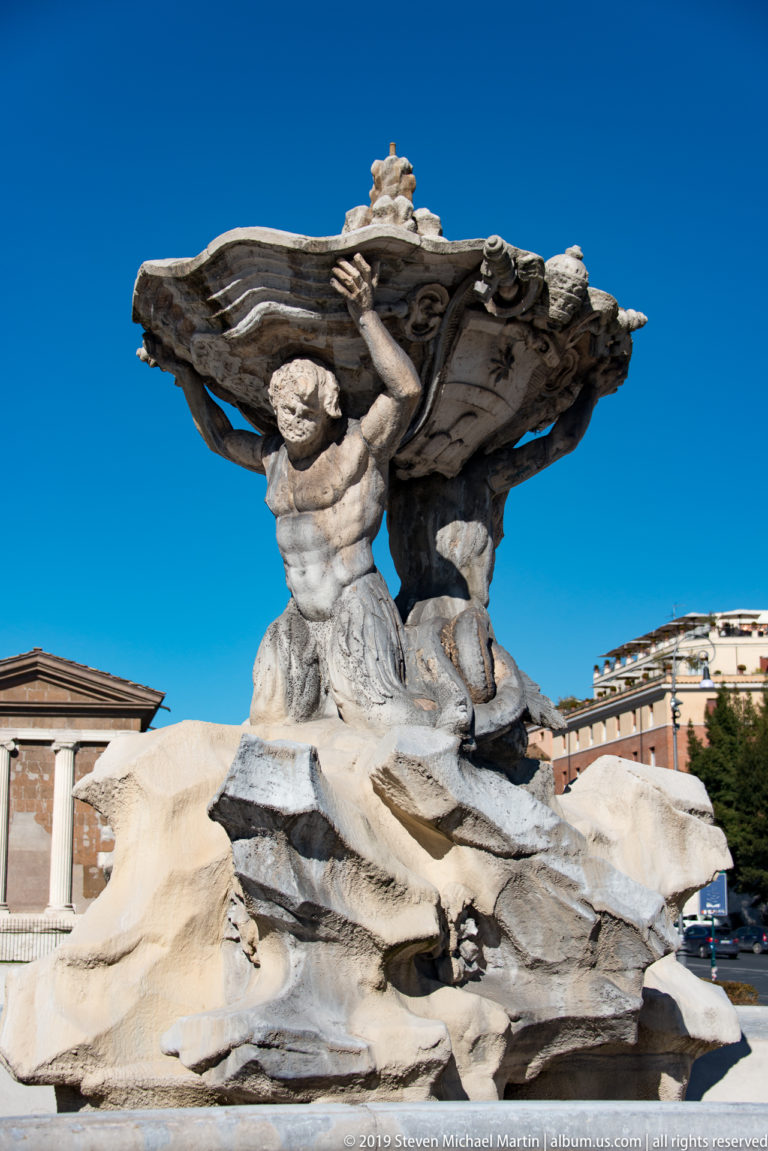 Two stone Tritons support a broad shell basin above rockwork in the Fontana dei Tritoni.