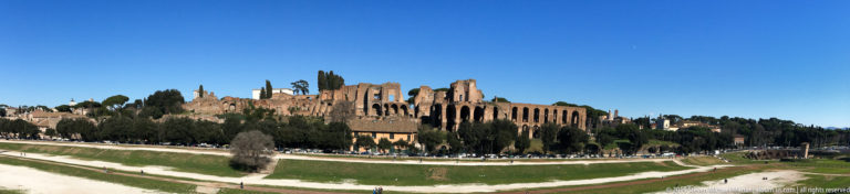 Ancient brick ruins on the Palatine Hill overlooking the long grassy and gravel floor of the Circus Maximus.