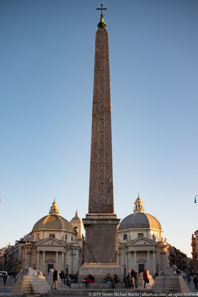 Flaminio Obelisk centered between the domes of Rome’s twin churches in Piazza del Popolo.