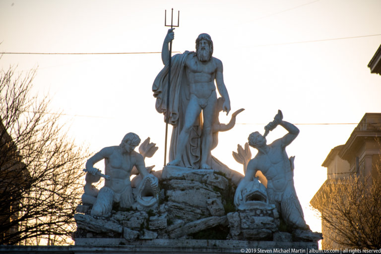 Neptune with trident above two Tritons and dolphins in the Fontana del Nettuno at Piazza del Popolo.
