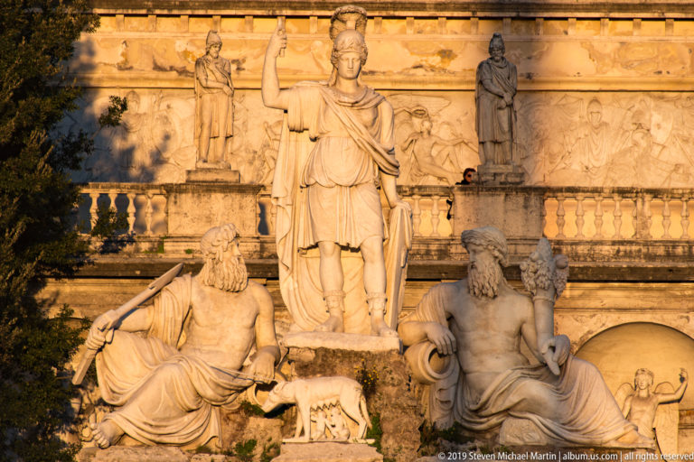 Dea Roma fountain with helmeted Roma, reclining river figures, and the she-wolf with Romulus and Remus.