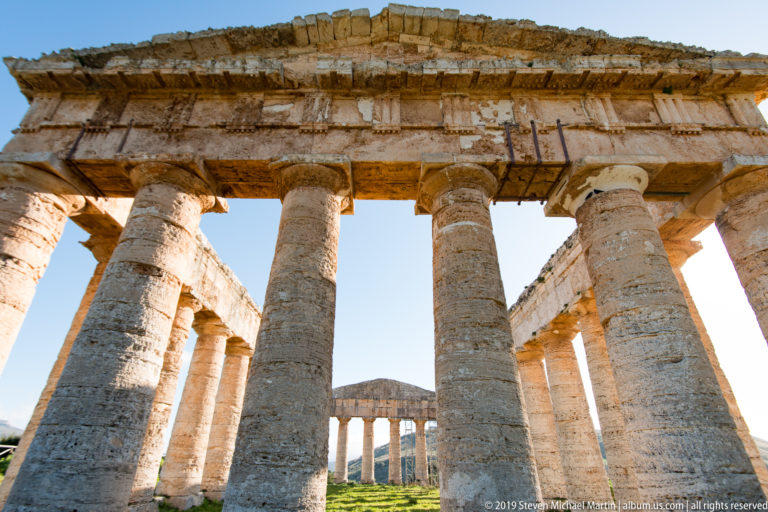 View through tall Doric columns into the open interior and opposite colonnade of the Temple of Segesta.