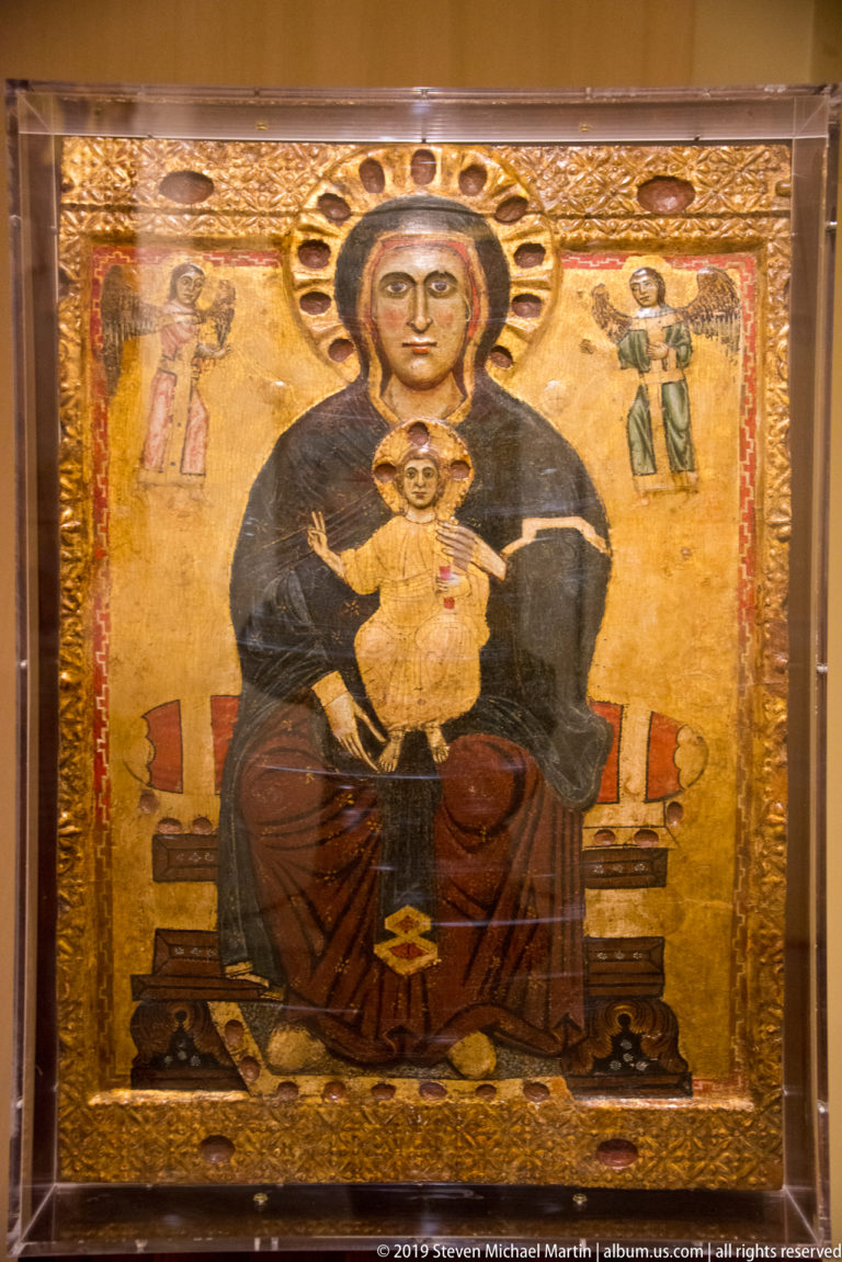 Gold-ground panel of the enthroned Madonna holding the Christ Child, with small angels standing to either side.