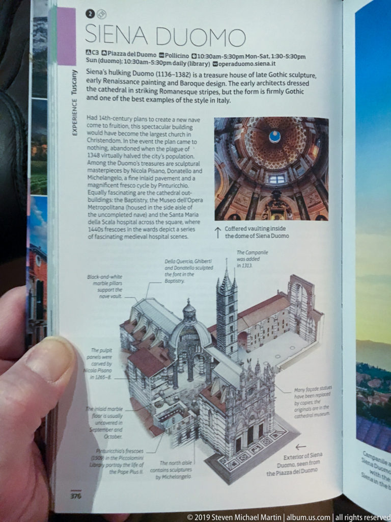 Hand holding a printed guide page with an architectural diagram of Siena Cathedral, explanatory text, and a small dome photograph.