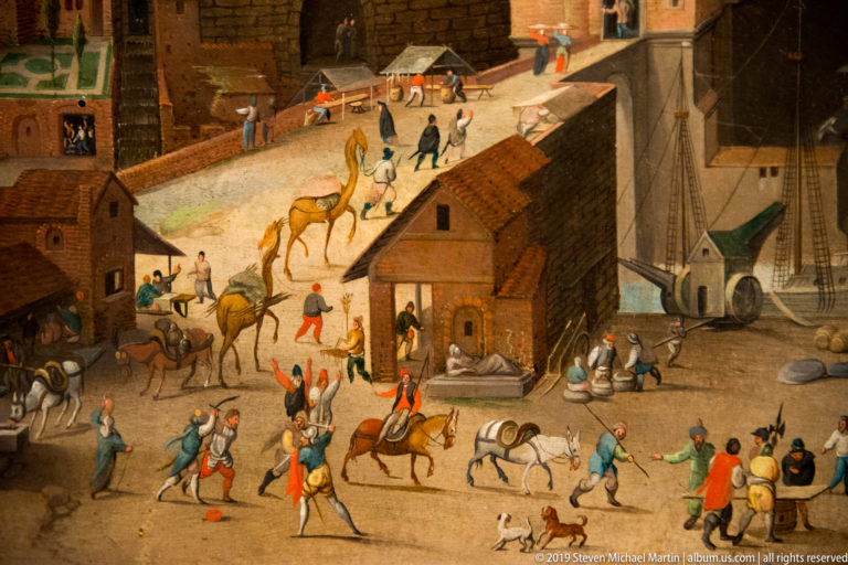 Horses and camels move through a crowded painted street between brick buildings, pedestrians, and a nearby harbor.