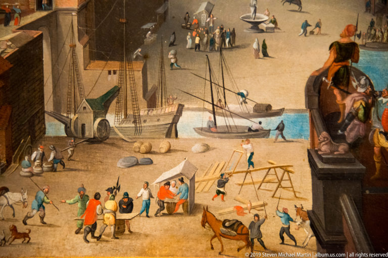 Workers handle timber beside sailing ships at a harbor, with pedestrians and a sculptural monument in the foreground.