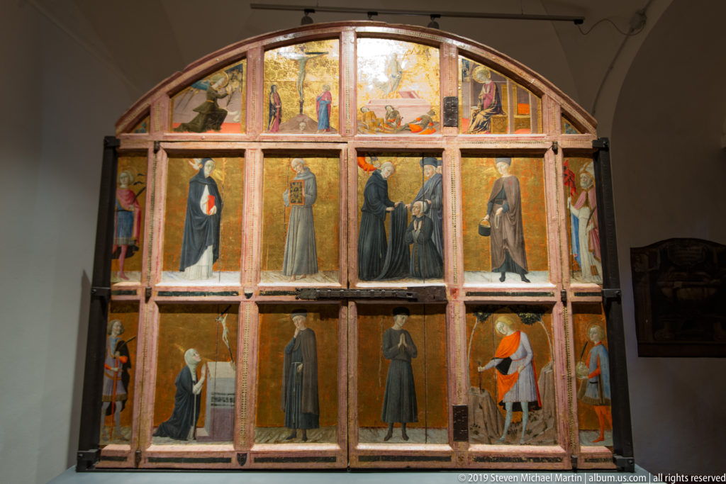 Large arched multi-panel altarpiece with full-length saints, smaller narrative scenes, wooden divisions, and gilded backgrounds.