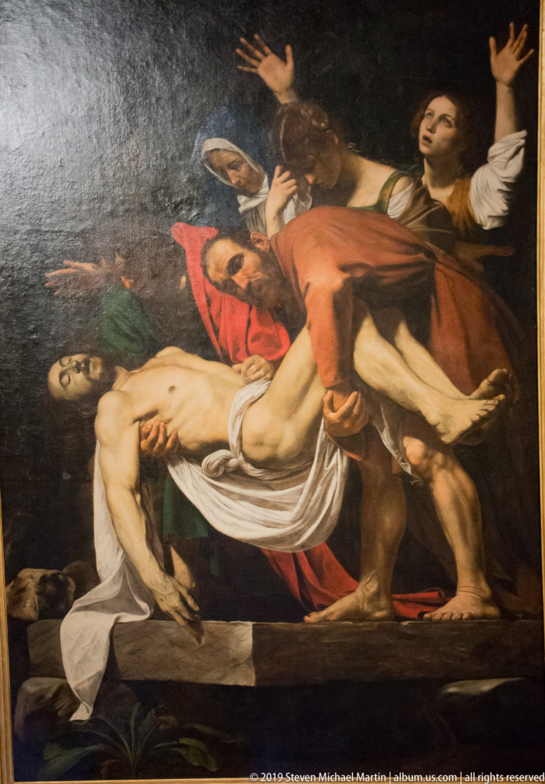 Religious painting of mourners carrying Christ's pale body, with grieving women raising their arms behind the group.