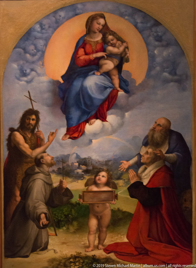Raphael's Madonna di Foligno with the Virgin and Child above saints, a kneeling donor, and a small angel holding a tablet.