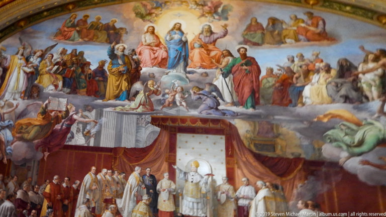 Detail of a papal ceremonial fresco with saints on clouds above a pope and rows of clergy beneath red draperies.