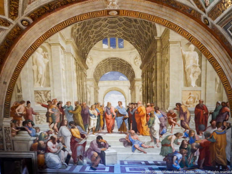 Raphael's School of Athens with philosophers gathered on marble steps beneath monumental classical barrel vaults.