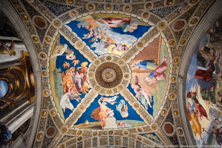 Frescoed ceiling with a central round medallion, surrounding figurative scenes, decorative ribs, rosettes, and painted architectural ornament.
