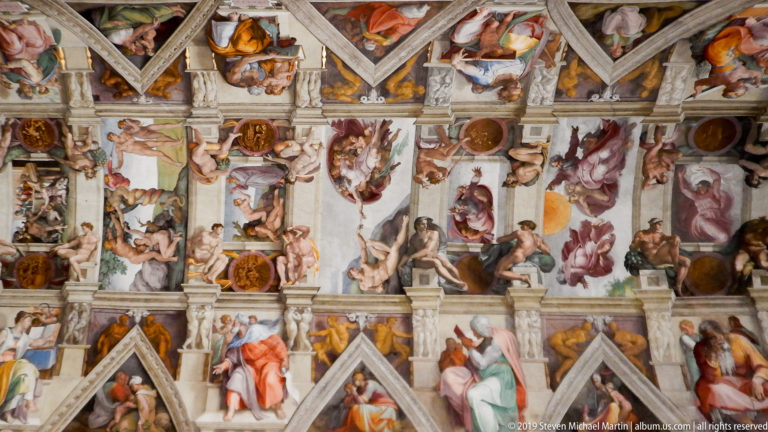 Broad view of the Sistine Chapel ceiling with seated monumental figures, narrative panels, medallions, and painted architectural divisions.