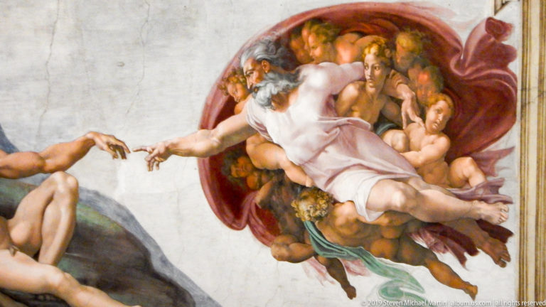 Close detail of Michelangelo's Creation of Adam showing God and accompanying figures reaching toward Adam's outstretched hand.