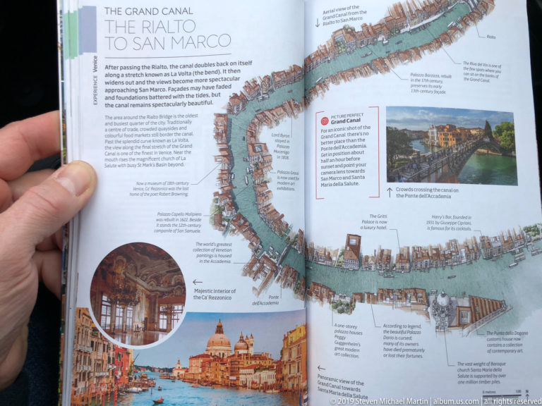 Open guidebook centered on a detailed illustrated map of Venice's Grand Canal with inset landmark photographs.