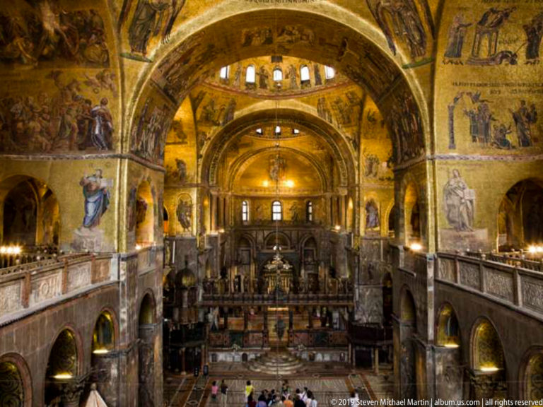 Central interior view of St. Mark’s Basilica with gilded mosaic vaults, arcades, galleries, and sanctuary beyond.