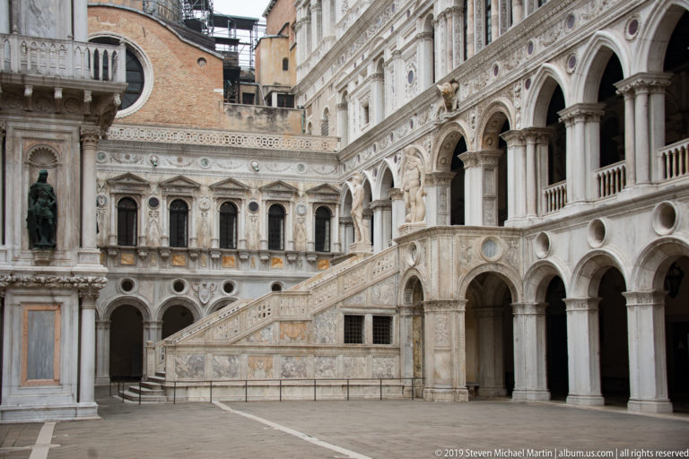 Wide view of the Scala dei Giganti crossing the ornate arcaded courtyard of the Doge’s Palace.