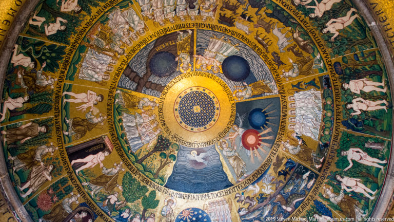 Concentric mosaic registers of biblical scenes arranged around a bright central medallion in a dome of St. Mark’s Basilica.