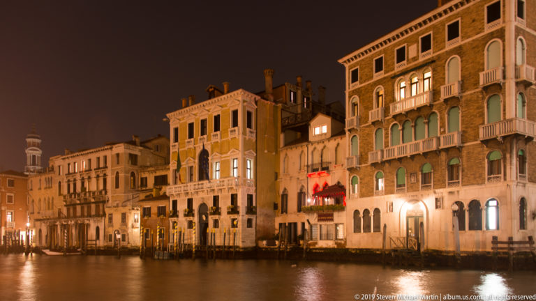 Illuminated palazzi along the Grand Canal under nighttime illumination in Venice.