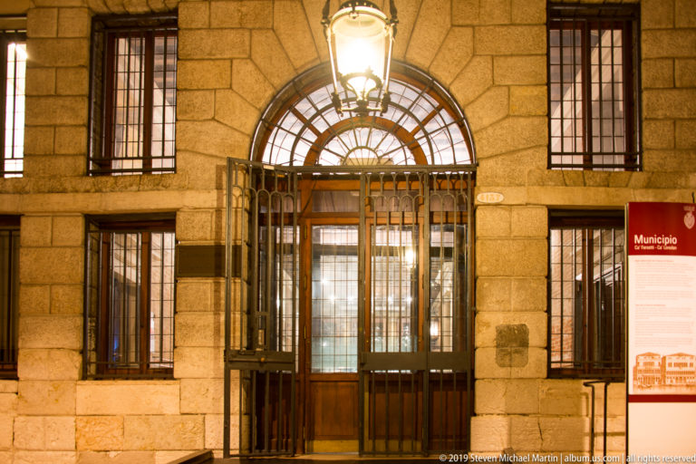Gated entrance to a Venice municipal building under nighttime illumination in Venice.