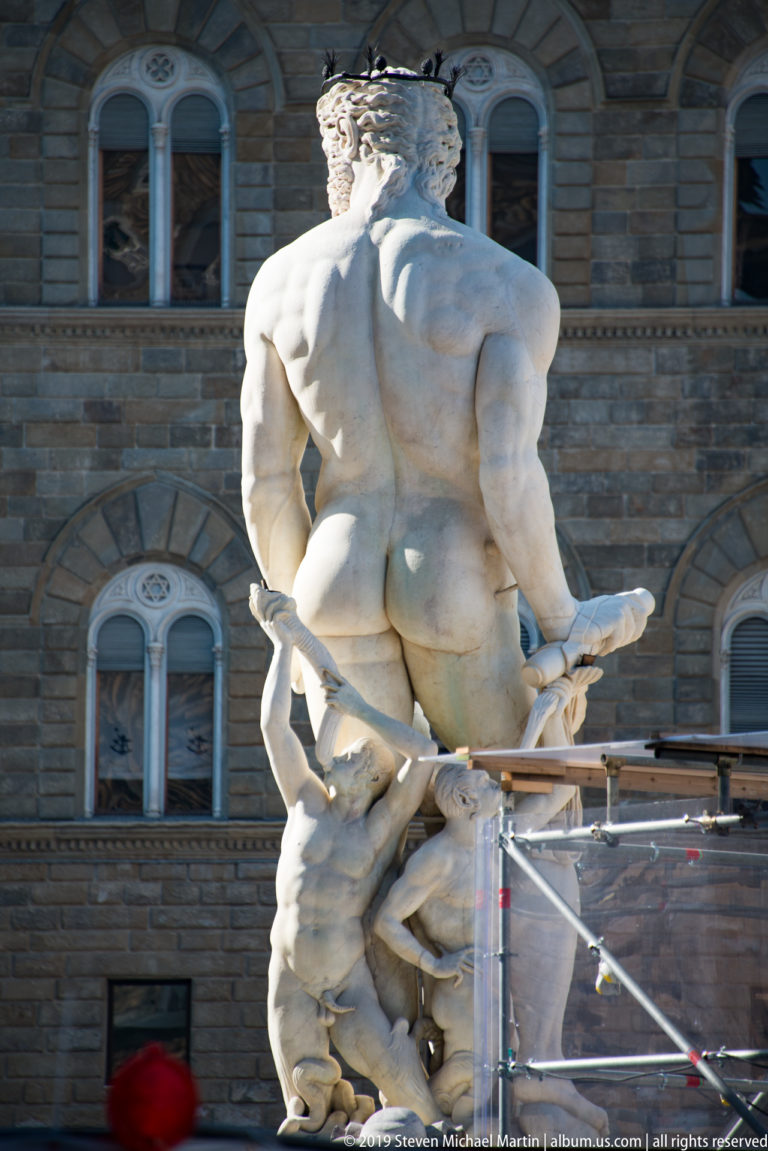 Rear view of the marble Hercules and Cacus group, emphasizing Hercules’s muscular back against Palazzo Vecchio.