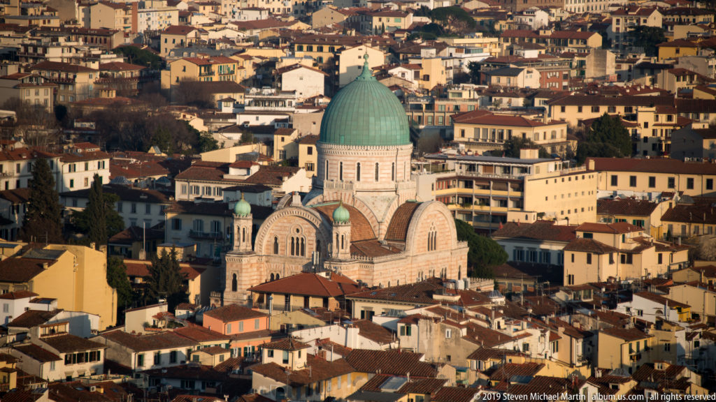 Great Synagogue of Florence with a large green dome and striped façades rising above surrounding terracotta rooftops.