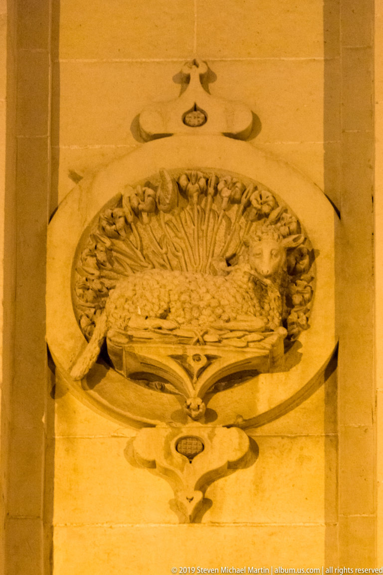 Oval stone medallion containing a radiating fan or shell motif, framed by curved moldings and stylized ornament.