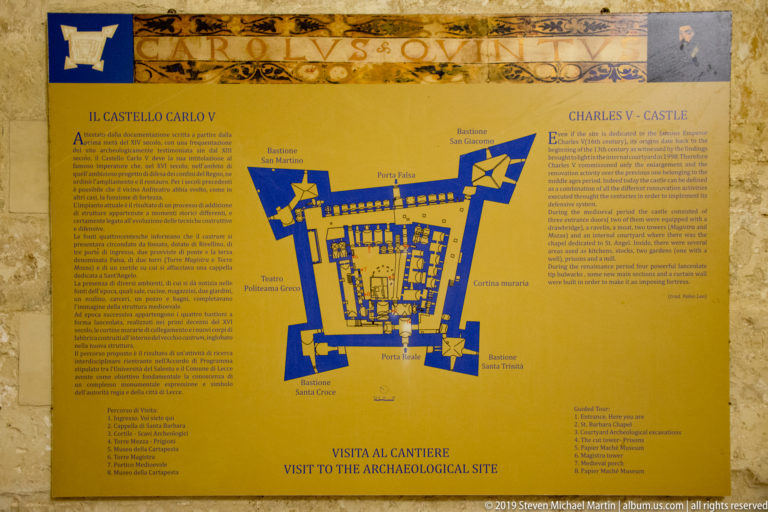 Bilingual Castello Carlo V interpretation panel with a blue fortress plan, labeled features, and Italian and English text.