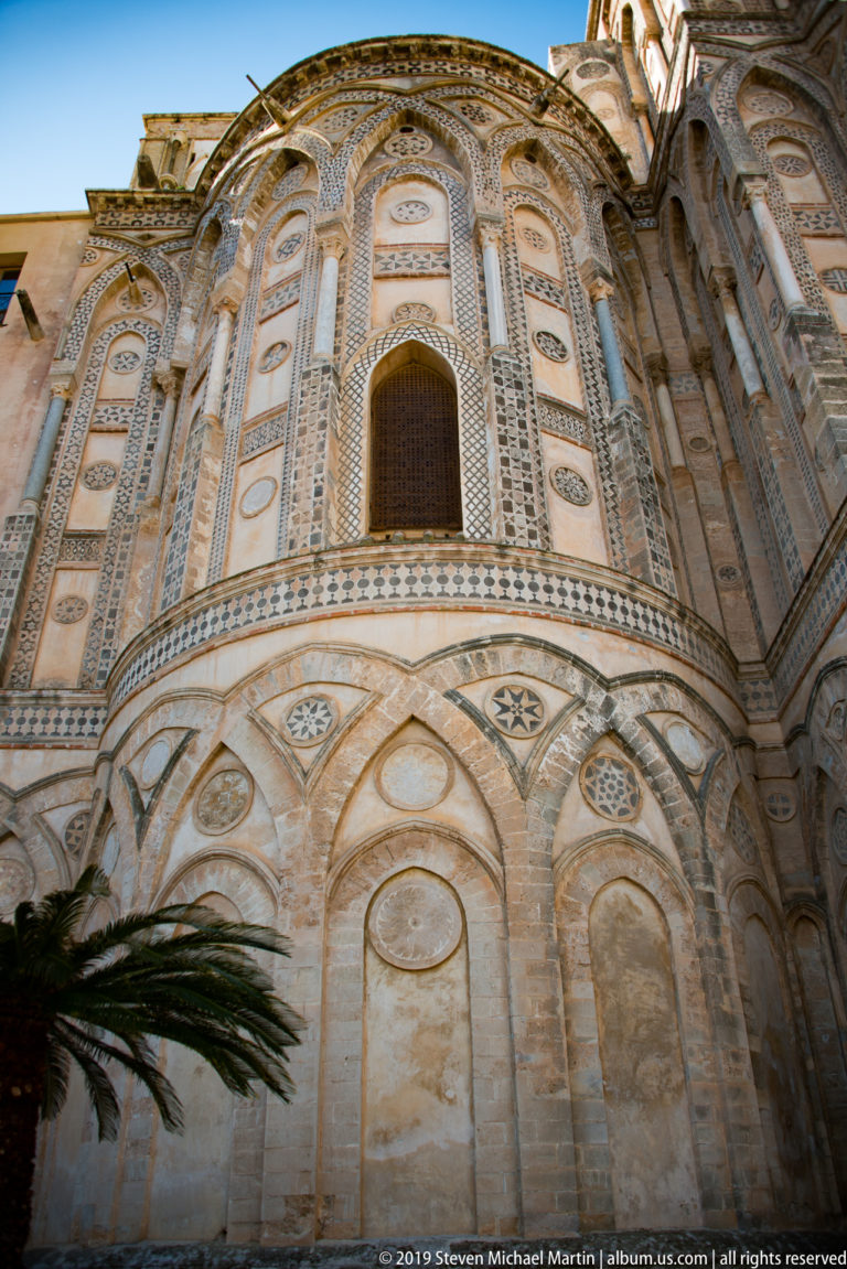 An oblique close view shows the cathedral’s central arch, patterned bands, and smaller circular façade ornaments.