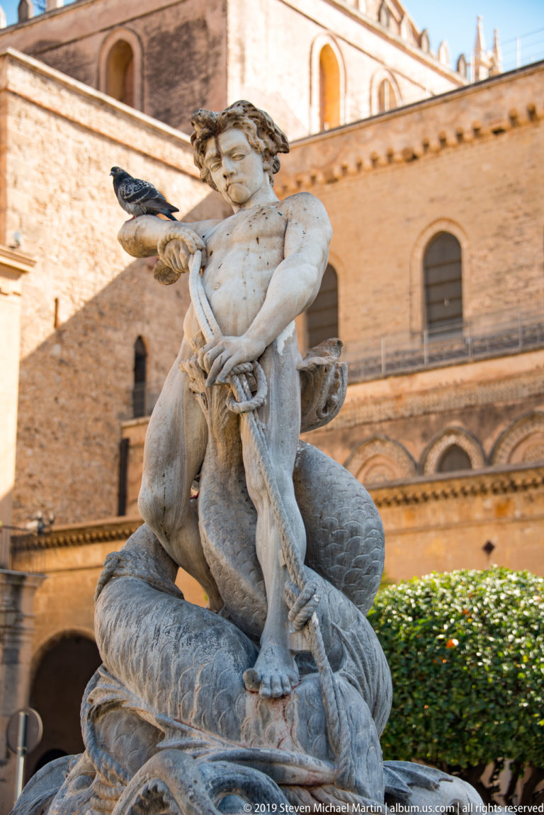 Close view of the Triton figure and carved creatures atop Monreale’s Fontana del Tritone.