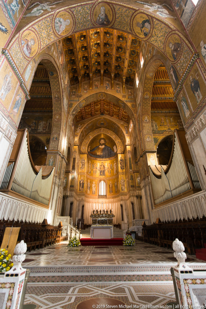 An elevated view frames the cathedral altar and gilded apse beneath a broad decorated arch.