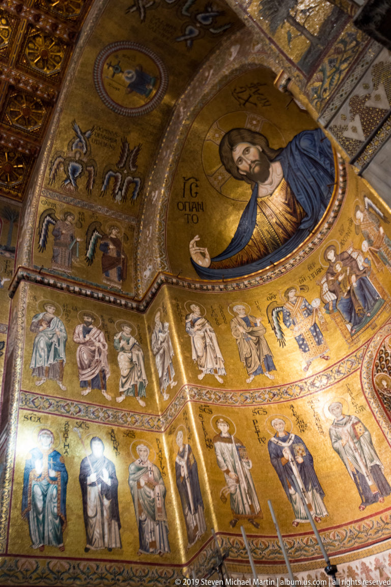 A haloed bearded figure holds a book in a close gold-ground mosaic.