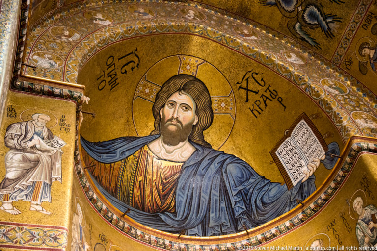 Christ Pantocrator enthroned in the central apse mosaic, blessing with one hand and holding an open book.