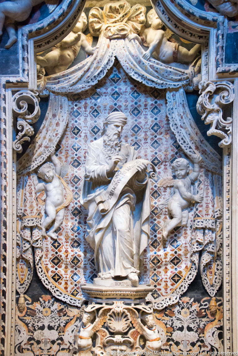 Jeremiah stands with a scroll in an ornate niche, with a smaller kneeling figure beside him.
