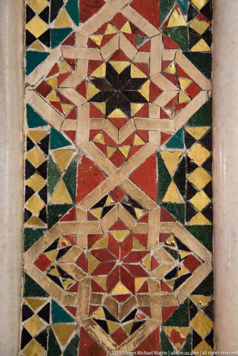 Angular bands of pale and colored stone interlock across a close view of the floor.