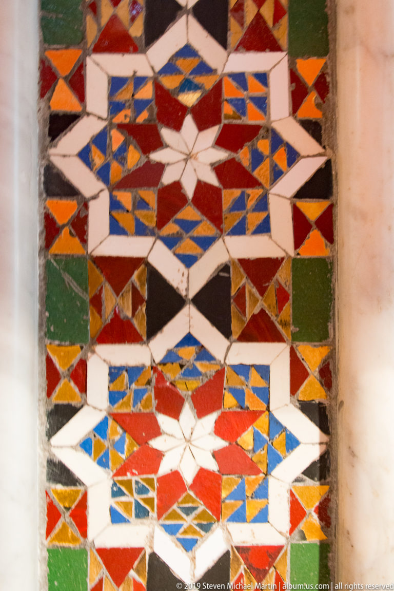 A close mosaic pavement combines colored stars, crosses, diamonds and zigzag bands.