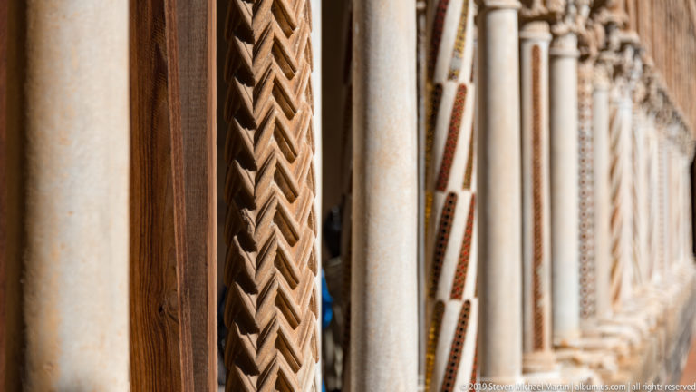 A column shaft with a vertical band of red, yellow, black, and green geometric inlay.