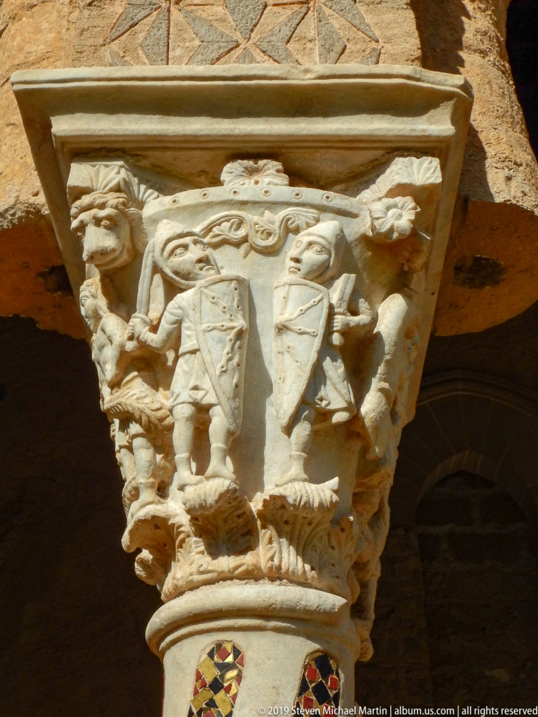 A carved capital rests above two columns with contrasting colored geometric inlay.