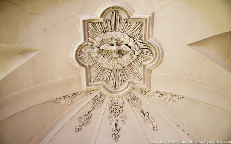 White stucco ceiling rosette with layered foliage, radiating ribs, and delicate ornamental relief.