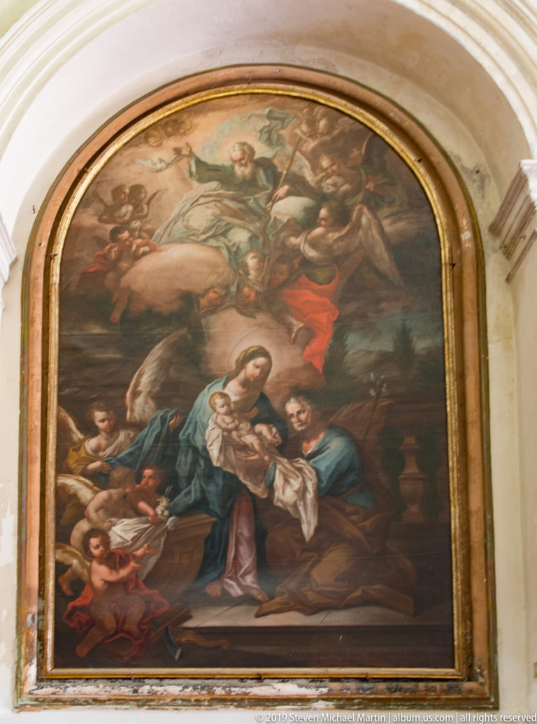 Large arched church painting with the Virgin in blue and rose surrounded by angels and kneeling figures.