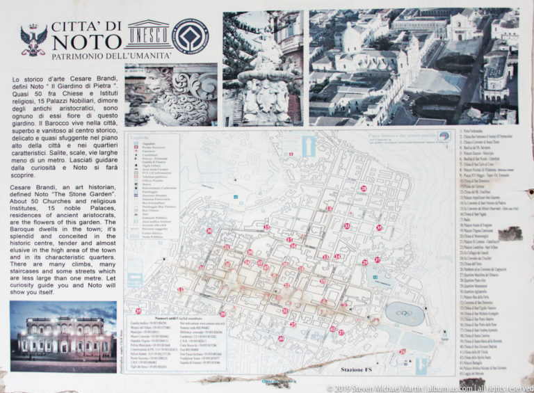 Outdoor visitor panel with historical text, archival photographs, and a numbered map of Noto’s historic center.
