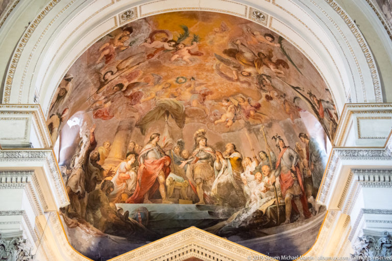 Large religious painting covering the curved upper apse, with many figures arranged beneath a heavenly scene.