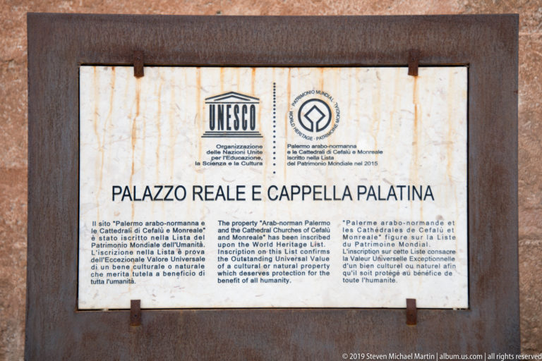 Stone UNESCO plaque reading Palazzo Reale e Cappella Palatina with UNESCO and World Heritage emblems and multilingual text.