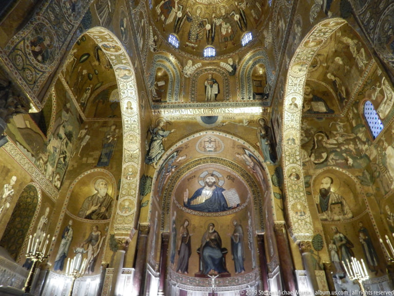 Wide upward view of the Palatine Chapel sanctuary with Christ, Virgin and Child, saints, arches, and extensive gold mosaics.