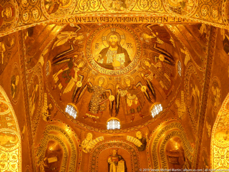 Christ Pantocrator in a gold mosaic dome surrounded by radiating angels, with saints and windows below.