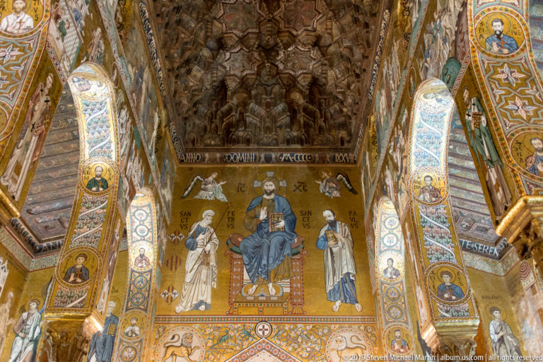 Enthroned Christ between Saints Peter and Paul on gold mosaic beneath the projecting wooden muqarnas ceiling.