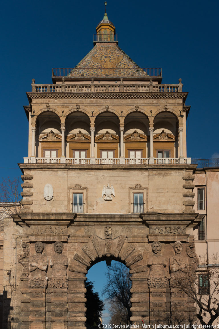 Full view of Porta Nuova with rusticated arch, sculpted atlantes, arcaded loggia, balustrade, eagle roof, and lantern.
